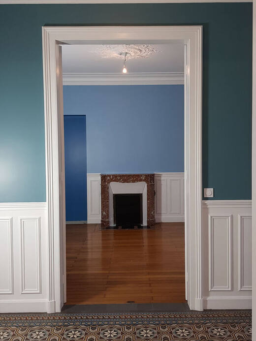 Séjour bleu, soubassements blancs et cheminée
